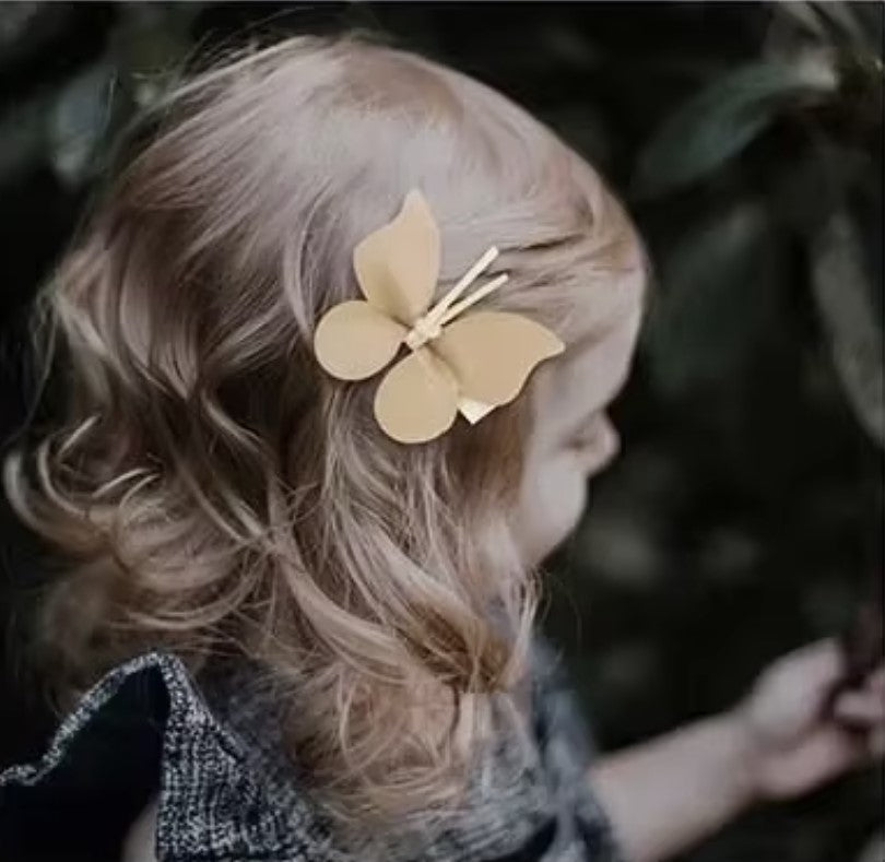 A girl with a beautiful butterfly hair accessory from Haile Cozzie Soles