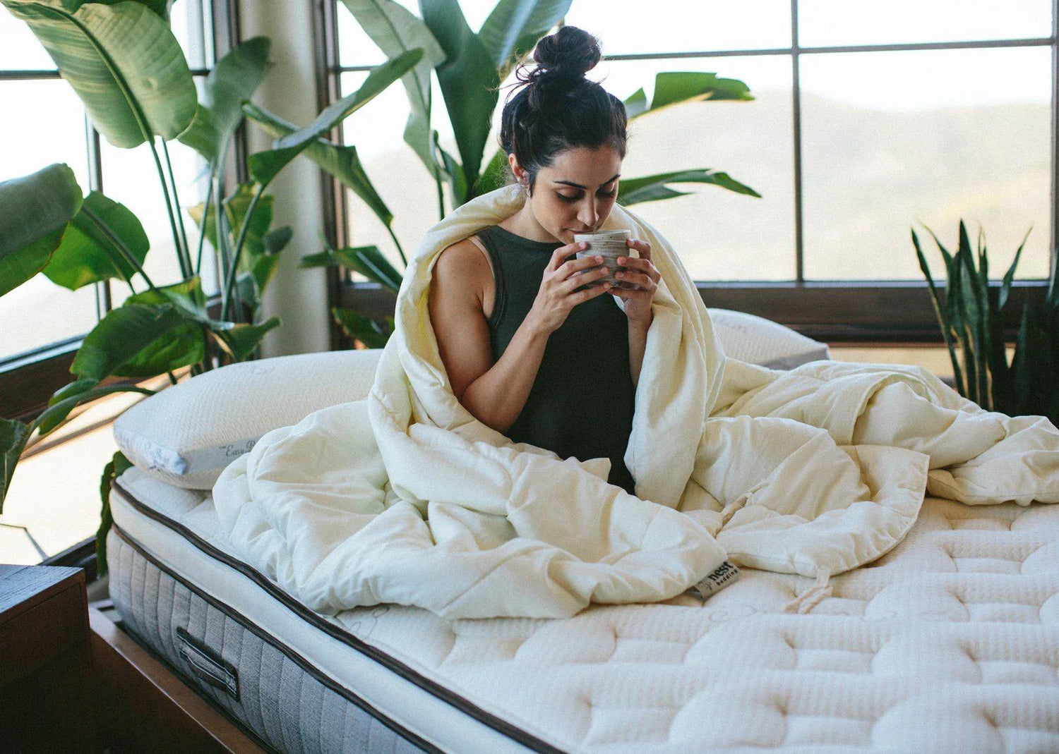 A woman in her bed with a comforter